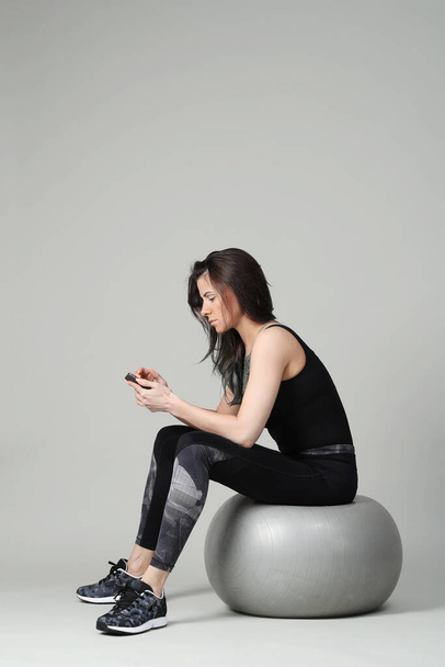 Woman doing exercise with big ball on the white background - Foto, afbeelding