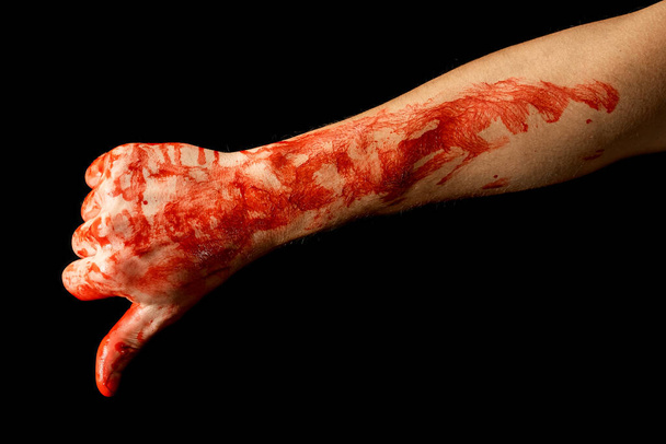 Miehen kädet osoittavat erilaisia eleitä veressä mustalla taustalla. Peukalo alas veressä - Valokuva, kuva