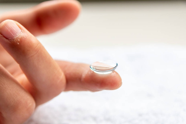 Kontaktlinse am Finger zur Korrektur von Kurzsichtigkeit und Sehstörungen durch Optiker oder Augenarzt ist hygienisch zu handhaben, um Weitsichtigkeit mit transparentem Einweglinsenmakro zu korrigieren - Foto, Bild