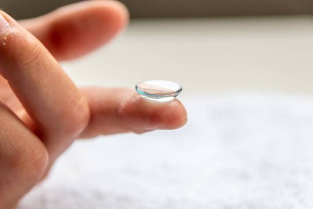 Contact lense on finger to correct nearsightedness and blurred vision eyesight by optician or oculist is to handle with hygiene to correct farsightedness with transparent disposable lense macro - Photo, Image