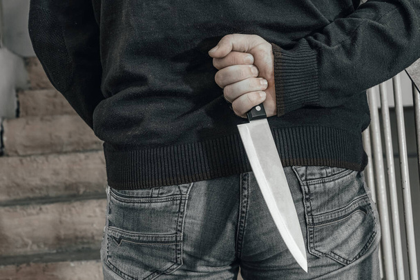 Человек с ножом я на посадке. Убийца прячется с ножом перед нападением. темы насилия и убийства. вор, насильник, маньяк - Фото, изображение