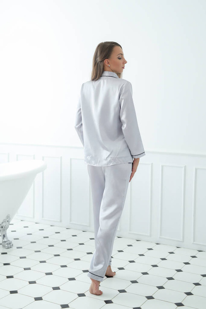 Mode. Vrouw poseren in zilveren pyjama - Foto, afbeelding