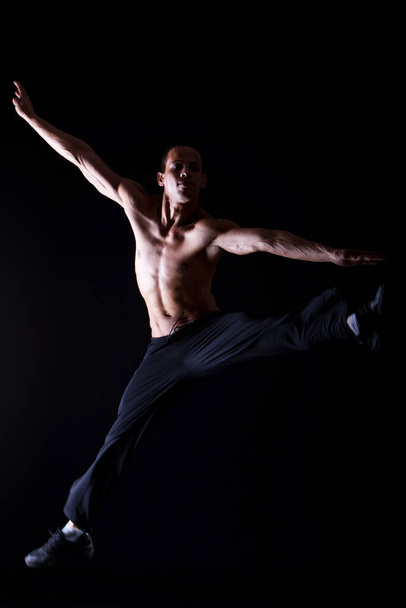 młody i mięśni hiszpanin tancerz na czarnym tle - Zdjęcie, obraz