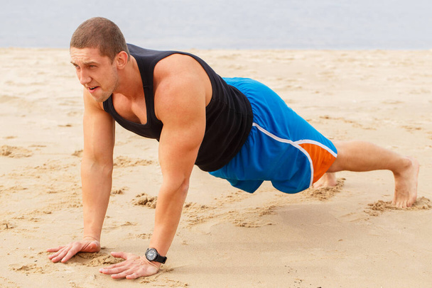 Спорт, фитнес. Человек делает отжимания на пляже
 - Фото, изображение