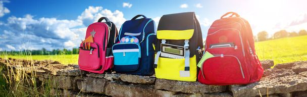 Colourful children schoolbags outdoors on the field - Fotografie, Obrázek