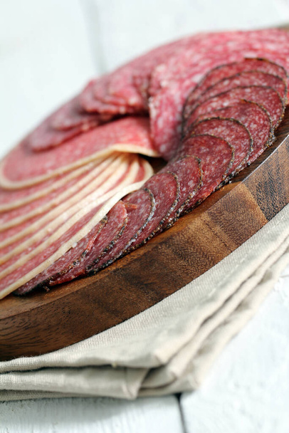 vers en lekker salami over houten oppervlak - Foto, afbeelding