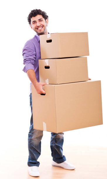 Joven y guapo chico llevando cajas sobre fondo blanco
 - Foto, Imagen
