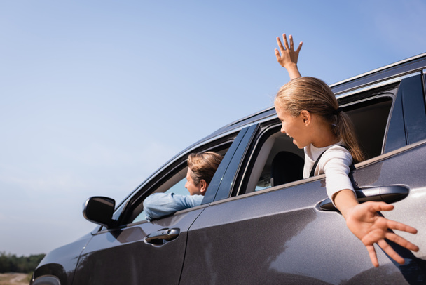 Szelektív fókusz a gyerek néz félre ablakán keresztül autó közel apa  - Fotó, kép