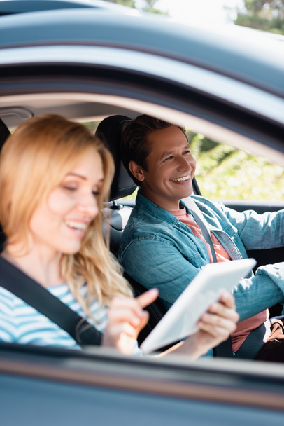 Selective focus of man driving car near wife using digital tablet  - Valokuva, kuva