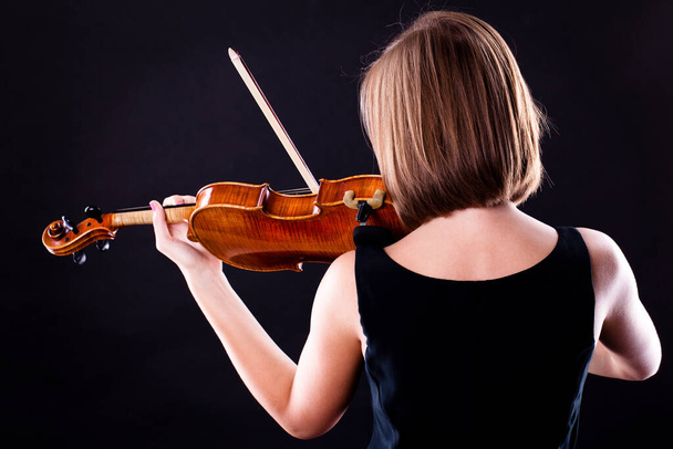 Woman with the violin over black background - Fotó, kép