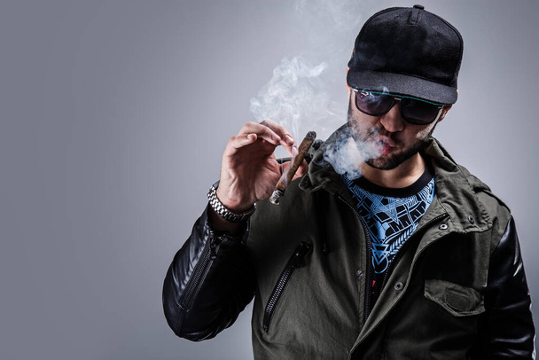 Handsome guy smoke a cigar - Фото, изображение
