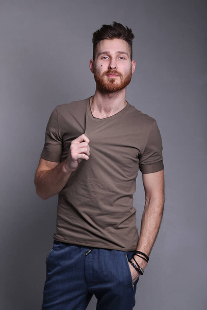 Handsome young man in casual clothing posing on grey background - Photo, Image