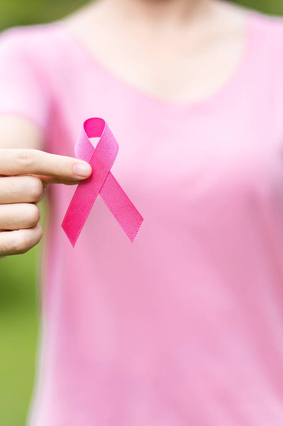 Οκτώβριος Μαστού μήνα ευαισθητοποίησης του καρκίνου του μαστού, ενήλικη γυναίκα σε ροζ T-shirt με το χέρι κρατώντας ροζ κορδέλα για την υποστήριξη των ανθρώπων που ζουν και ασθένεια. Παγκόσμια Ημέρα κατά του Καρκίνου, Γυναίκες, Μητέρες και Γυναίκες - Φωτογραφία, εικόνα