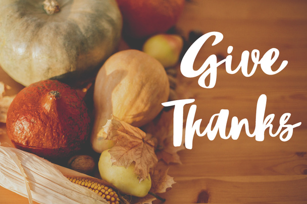 Joyeux Thanksgiving carte de vœux. Écrit à la main Remerciez le texte sur fond de citrouilles, feuilles d'automne, noix, légumes de récolte sur table en bois rustique. - Photo, image
