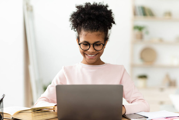 Happy African Teen Girl Étudier à l'ordinateur portable à la maison - Photo, image