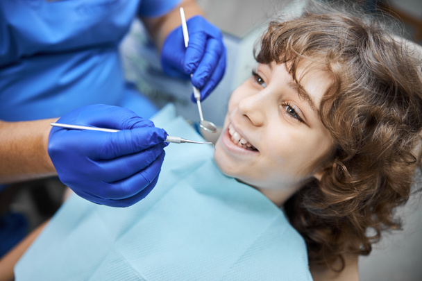Aranyos mogyorószemű gyerek, aki egy fogorvosi laborba látogat. - Fotó, kép