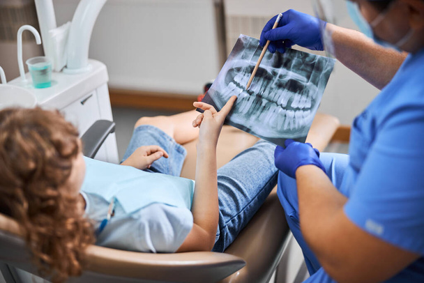 Hammaslääkäri osoittaa eri hampaita röntgenkuvassa - Valokuva, kuva