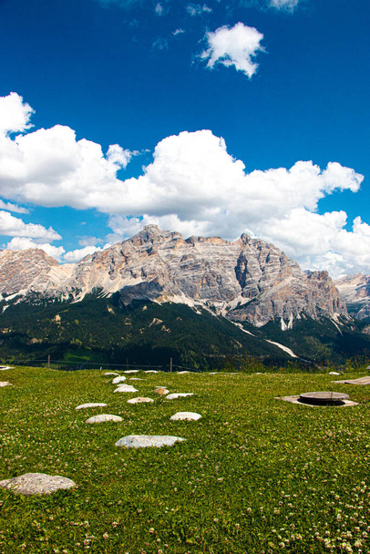 Panorama caratteristico delle Dolomiti. Il prato, le pietre, un cielo con imponenti nuvole nel contorno. - Foto, immagini