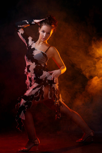 hermosa mujer bailando salsa danza sobre naranja humo fondo - Foto, Imagen