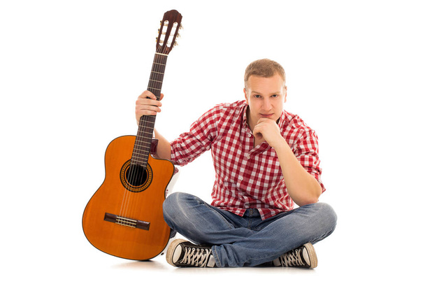 Młody muzyk z drewnianą gitarą - Zdjęcie, obraz