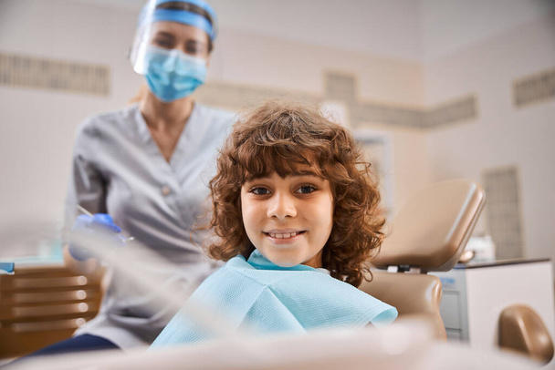 Nuori potilas näyttää onnelliselta hammaslääkärin toimistossa - Valokuva, kuva