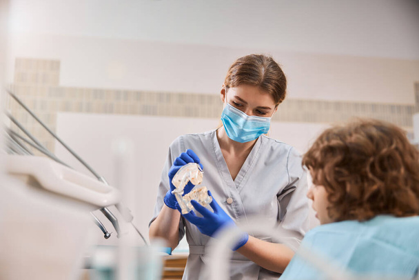 Ребенок в кабинете дантиста узнает о том, как работает стоматологическая гигиена - Фото, изображение
