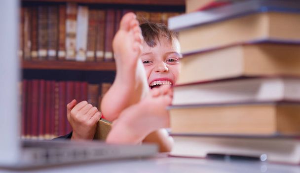 Apprendre peut être amusant. Jeune étudiante souriante et heureuse étudiant avec ordinateur et livres. Concentration sélective. - Photo, image