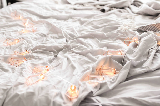 Καλώδιο με λαμπτήρες σε ένα κρεβάτι - Φωτογραφία, εικόνα