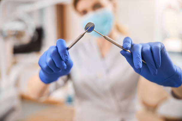 Dental tools in hands of a qualified professional - 写真・画像