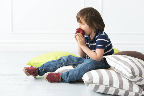 Słodki, uroczy chłopiec jedzący jabłko - Zdjęcie, obraz