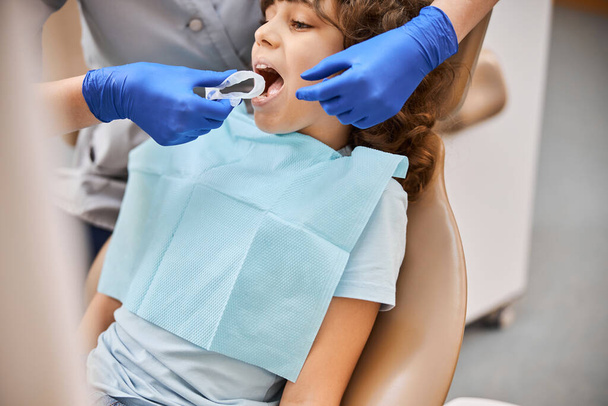 Dentista usando uma barragem de borracha dental descartável - Foto, Imagem