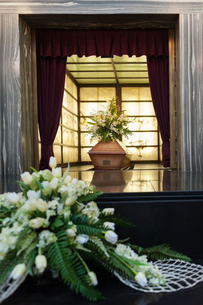 Caixão de madeira com flores funerárias no crematório
 - Foto, Imagem