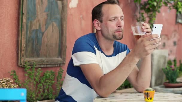 Man with smartphone drinking beer - Video, Çekim