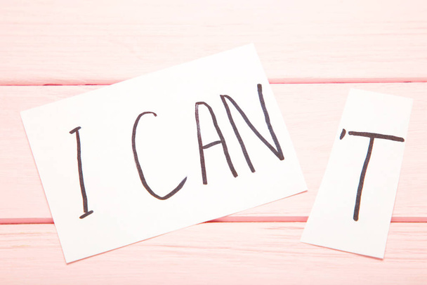 I can self motivation - cutting the letter t of the written word I can't so it says I can. Top view - Foto, Bild