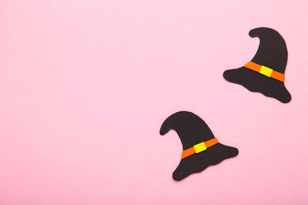 Witch hat on pink background. Halloween paper decorations on pink background with copy space. Top view - Foto, Imagen