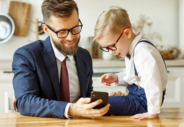 biznesmen ojciec z młodym uczniem syn używa smartfona do wyszukiwania informacji - Zdjęcie, obraz