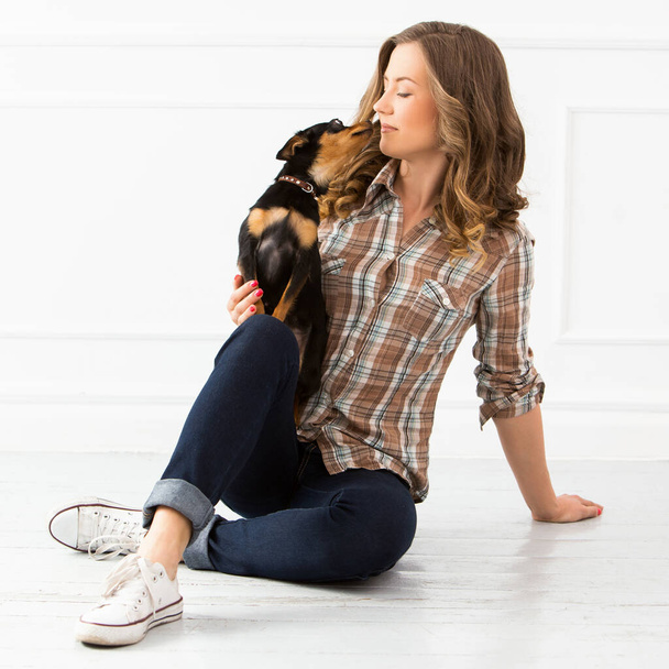 Mulher atraente com cão no chão
 - Foto, Imagem