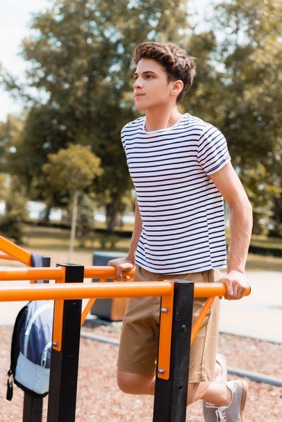 sportive teenager boy exercising on horizontal bars - Foto, immagini