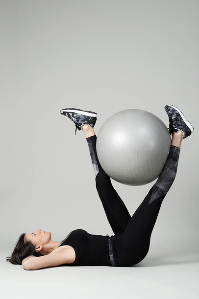 Mulher fazendo exercício com grande bola no fundo branco - Foto, Imagem