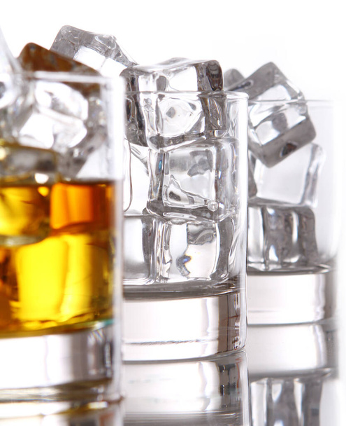 Sklenice studené whisky s ledem izolovaným nad bílou - Fotografie, Obrázek