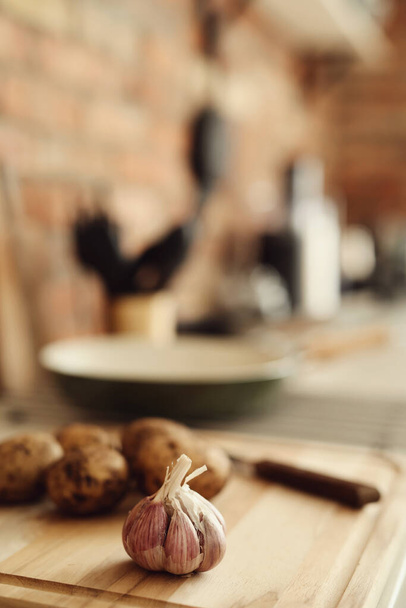 Keittiö, ruoanlaitto. Raaka peruna leikkuulaudalla - Valokuva, kuva
