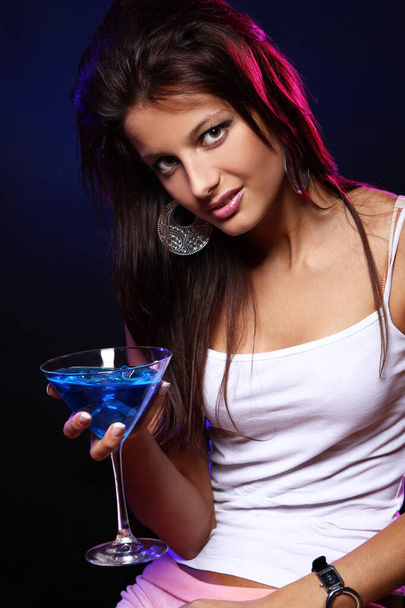 Young and beautiful woman with a blue cocktail in the nightclub - Fotografie, Obrázek