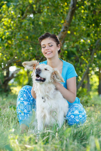 Linda chica en vestido azul con perro adorable - Foto, imagen