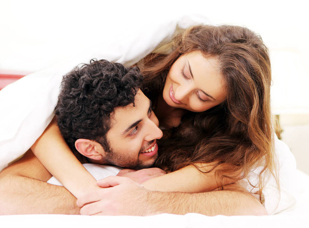 幸せな若いカップルの肖像画で一緒にリラックスベッド - 写真・画像