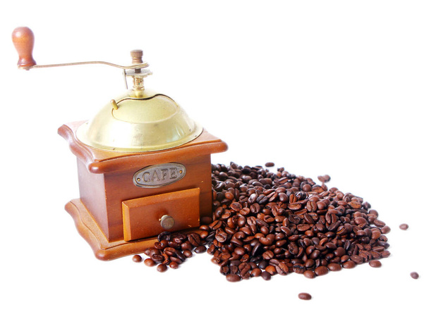 Старая кофемолка и жареный кофе в зернах на белом фоне - Фото, изображение