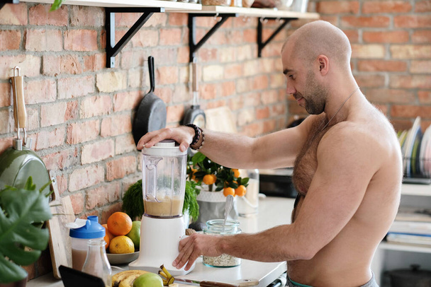 Handsome, shirtless man at kitchen - Foto, Imagen