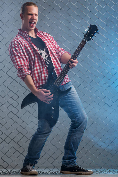 Genç, elektro gitarlı çılgın müzisyen. - Fotoğraf, Görsel