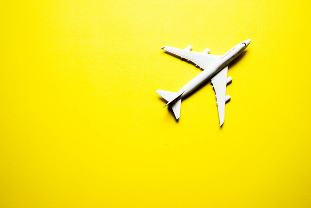 Avión de juguete miniatura sobre fondo amarillo. Viaje en avión - Foto, imagen