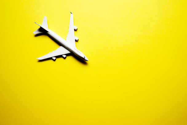 Миниатюрный игрушечный самолет на жёлтом фоне. Поездка на самолете - Фото, изображение