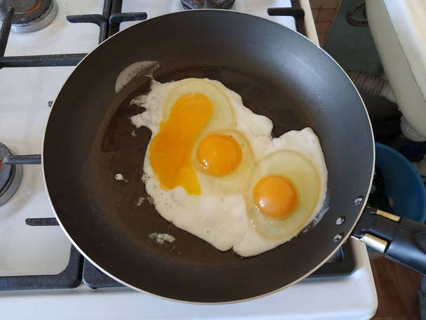パンで揚げた3個の卵からスクランブルエッグ - 写真・画像